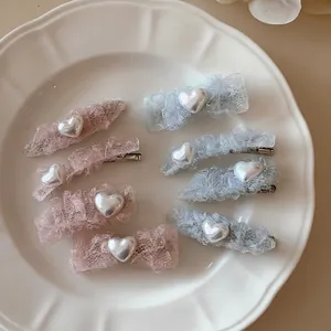 Barrettes à cheveux élégantes en dentelle avec perles roses et bleues sur un plat blanc