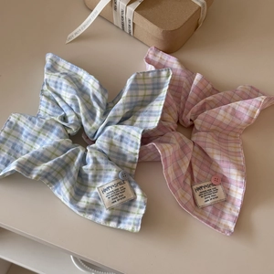 Pink and blue plaid oversized hair scrunchies with decorative buttons and labels