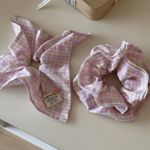 Detailed view of pink plaid scrunchie set with bow detail and brand tag labels