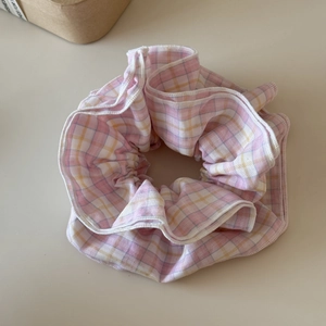 Close-up of pink and yellow plaid hair scrunchie with soft cotton fabric texture