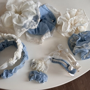 Gros plan de chouchous en dentelle bleus et blancs, bandeaux et pinces à nœud perlé