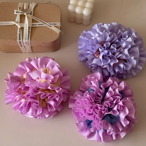Close-up of handmade pleated floral scrunchies in pastel colors with gift packaging
