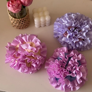 Detailed view of handmade pleated carnation scrunchies with striped ribbon texture