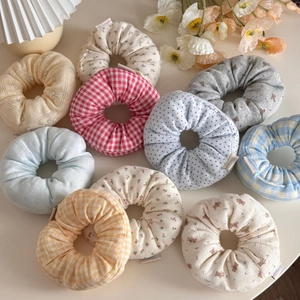 Detailed overhead view of assorted floral and plaid fabric scrunchies in various patterns