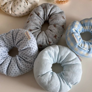Detail of five oversized floral and plaid fabric scrunchies with various textures