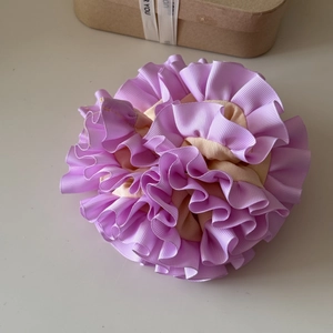 Detail of multi-layered lavender and apricot pleated scrunchie with textured ribbon