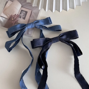 Detail einer blauen Denim-Haarschleife mit langen Bändern und weißen Ziernähten