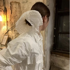Close-up of white lace scrunchie with oversized double-layer hollowed-out pleated design