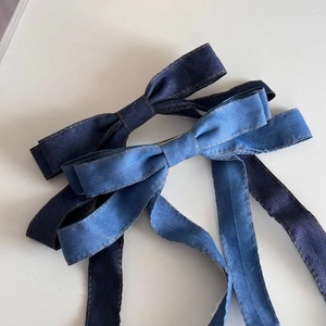 Detailansicht von marineblauen und hellblauen Denim-Schleifen-Haarspangen mit Bändern