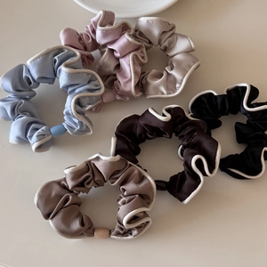 Detail view of 5-piece satin scrunchie set with white contrast edges in various colors
