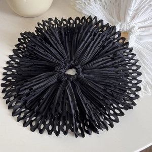 Macro shot of black pleated oversized hair scrunchie with laser-cut scalloped edges