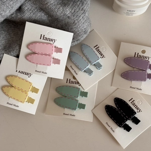 Detailed macro view of colorful candy-colored bullet hair clips on a white backcard