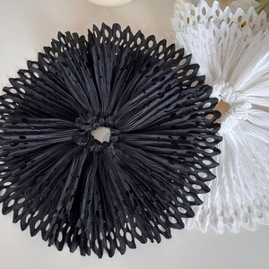 Handmade pleated hair scrunchies in black and white with laser-cut hollow edges