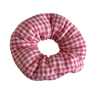 Classic red and white gingham checkered fabric scrunchie with soft ruffled cotton texture
