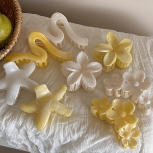 Dettaglio di fermacapelli frangipani con texture marmorizzata in acetato e molla