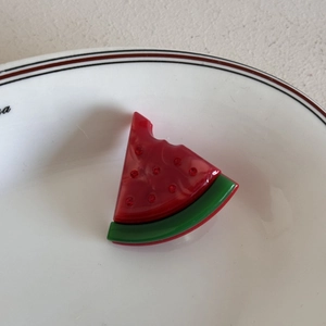 Dettaglio di un simpatico fermaglio per capelli in acrilico a forma di anguria con cristalli