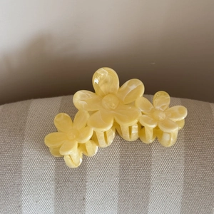 Dettaglio di una pinza per capelli a fiori gialli marmorizzati in resina
