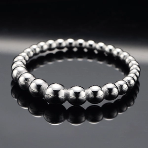 Polished stainless steel ring featuring minimalist gradient silver beads on a black surface