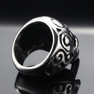 Vintage gothic skull patterns engraved on a stainless steel open ring with mirror reflection