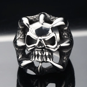 Dettaglio di un anello teschio punk con artigli d'aquila in acciaio argentato lucido