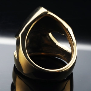 Dettaglio dell'anello punk vintage traforato placcato in oro su specchio nero