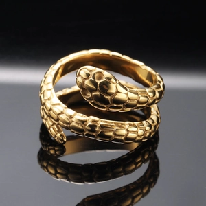 Polished gold titanium steel snake ring with textured scales on a black reflective surface