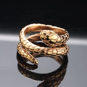 Macro shot of rose gold snake ring detailing scales and texture with reflection