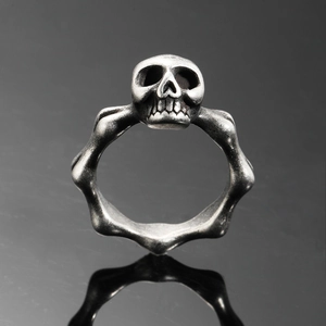 Vue macro d'une bague tête de mort punk vintage avec structure osseuse en argent antique