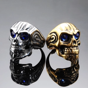 Punk style stainless steel skull ring featuring blue crystal eyes and ornate carvings
