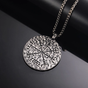 Macro del ciondolo bussola vichinga Vegvisir con finitura martellata e acciaio ossidato