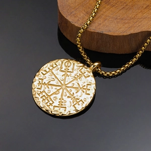 Dettaglio del ciondolo bussola vichinga Vegvisir dorata con bordi martellati e catenina