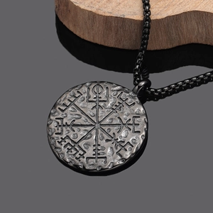Primo piano del ciondolo bussola vichinga Vegvisir vintage su base in legno scuro