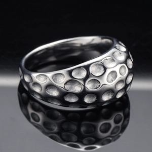 Detailed macro view of silver geometric ring featuring a unique hammered dimple texture