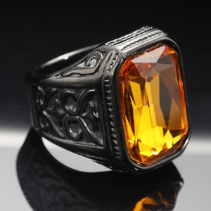 Macro shot of men's vintage black signet ring featuring a large amber yellow gemstone