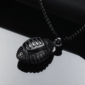 Detailed macro view of a vintage punk 3D rugby ball pendant in black stainless steel finish