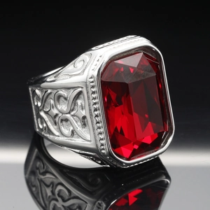 Macro detail of men's titanium ring featuring large red rectangular gemstone and vintage relief