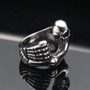 Gothic silver skull and skeletal hand stainless steel ring with vintage finish on black base