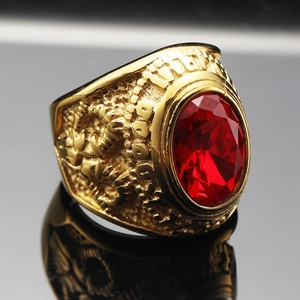 Macro shot of a vintage gold-plated men's ring featuring a large red oval gemstone and ornate carvings