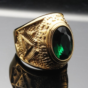 Macro view of gold vintage ring featuring green gemstone and All Seeing Eye carving