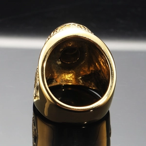 Macro shot of gold punk rings showing detailed side relief and textured engraving on metal