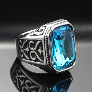 Macro detail of men's vintage steel ring with large sea blue gemstone and star carvings