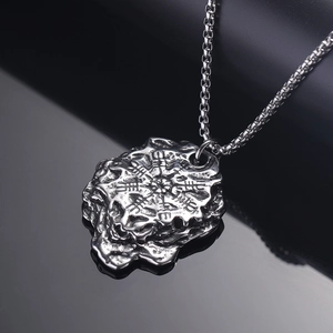 Vintage Viking compass pendant in silver steel on a dark reflective surface