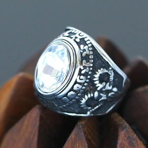 Macro shot of punk style steel ring with faceted clear gemstone and floral carvings