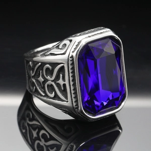 Macro shot of men's vintage steel ring with large blue gemstone and ornate side carvings