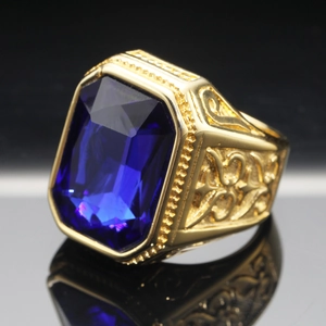 Detailed macro view of men's gold ring with a large rectangular blue sapphire gem