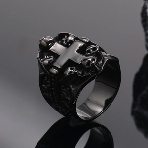 Détail d'une bague tête de mort noire en acier titane avec croix et gravures vintage