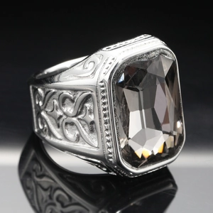 Macro shot of men's vintage steel ring with large rectangular grey gemstone and engraving