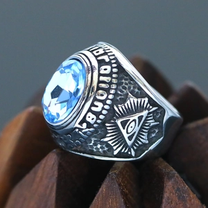 Detailed relief of Illuminati Eye of Providence on silver steel ring with blue gem