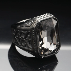 Macro detail of men's vintage black ring with large rectangular gemstone and gothic carving