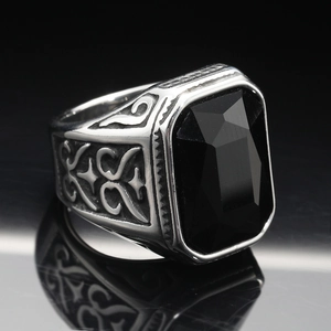 Macro shot of men's vintage steel ring featuring a large rectangular black gemstone inlay